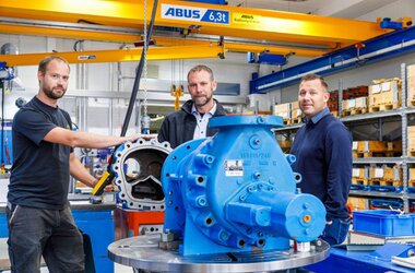 Mitarbeiter an Elektro-Kettenzug und vor ABUS Krane